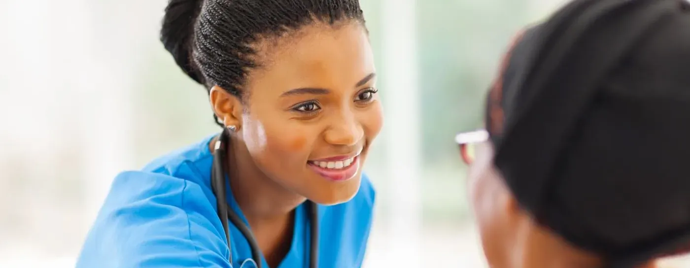 Live-in carer smiling and reassuring an older woman at home in Dartford, Kent