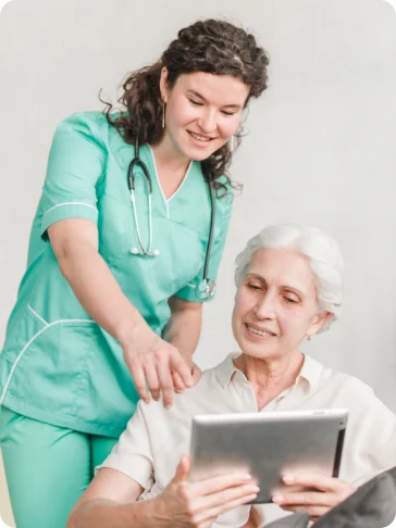 Respite carer helping an older woman use a tablet at home